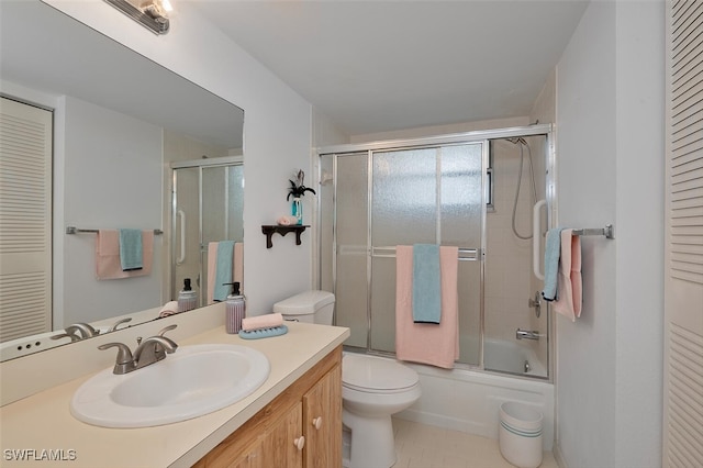 full bath featuring toilet, a closet, vanity, and combined bath / shower with glass door