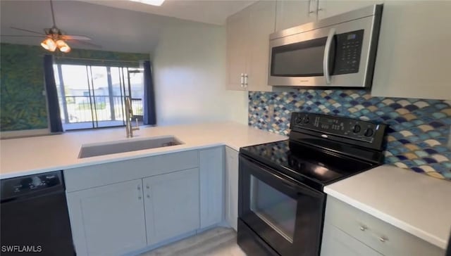 1521 SW 47th Ter Unit 204, Cape Coral, FL 33914 - kitchen with a sink, black appliances, decorative backsplash, ceiling fan, and light countertops