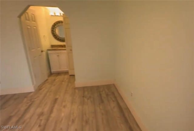 1521 SW 47th Ter Unit 204, Cape Coral, FL 33914 - hallway featuring arched walkways, light wood-style flooring, and baseboards