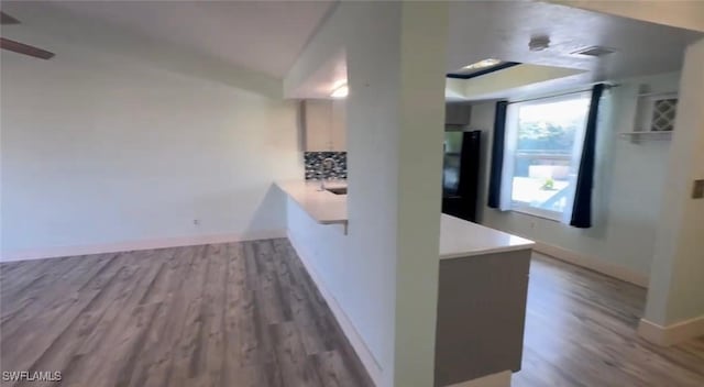 1521 SW 47th Ter Unit 204, Cape Coral, FL 33914 - kitchen with tasteful backsplash, freestanding refrigerator, baseboards, wood finished floors, and light countertops