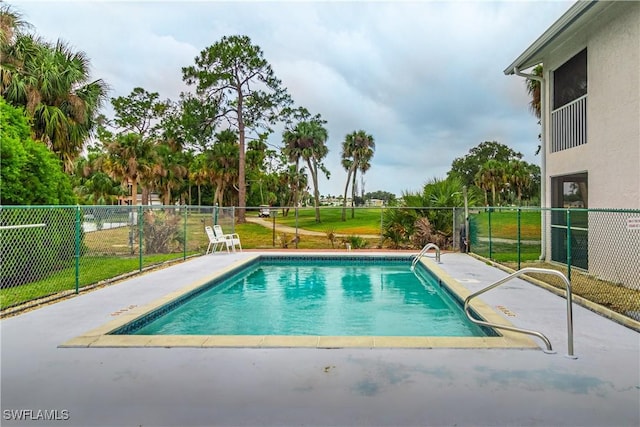 view of swimming pool featuring fence and a patio