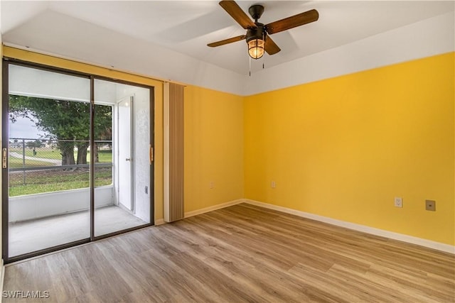 empty room featuring light wood-style floors, a ceiling fan, and baseboards