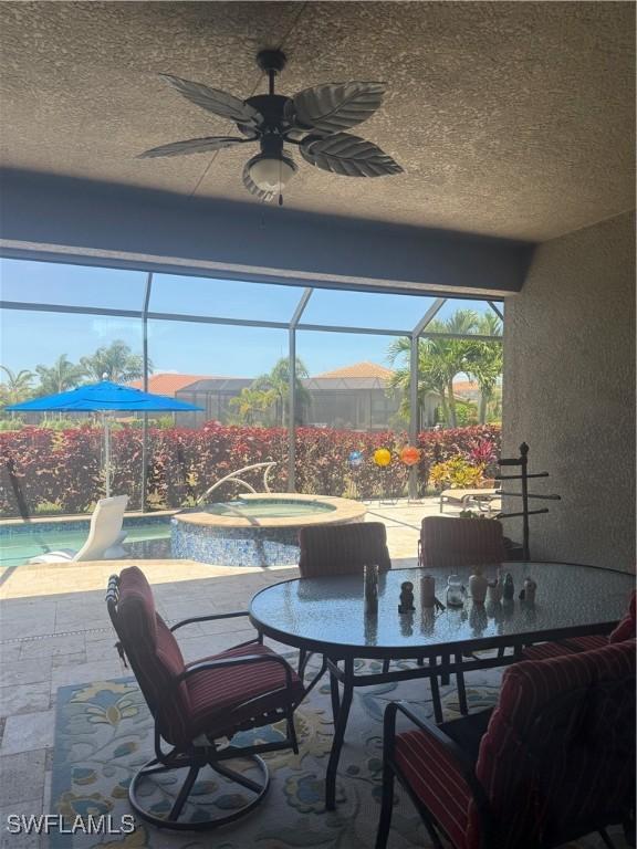 view of patio / terrace with ceiling fan, an outdoor pool, outdoor dining area, an in ground hot tub, and a lanai