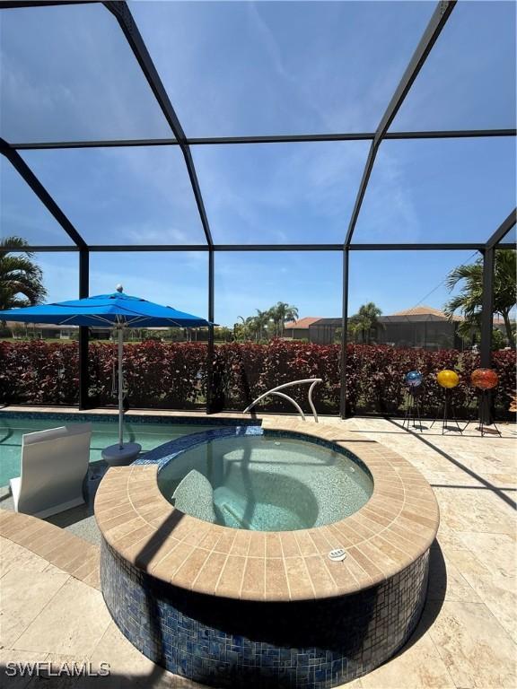 view of pool featuring a patio area, a lanai, and a pool with connected hot tub