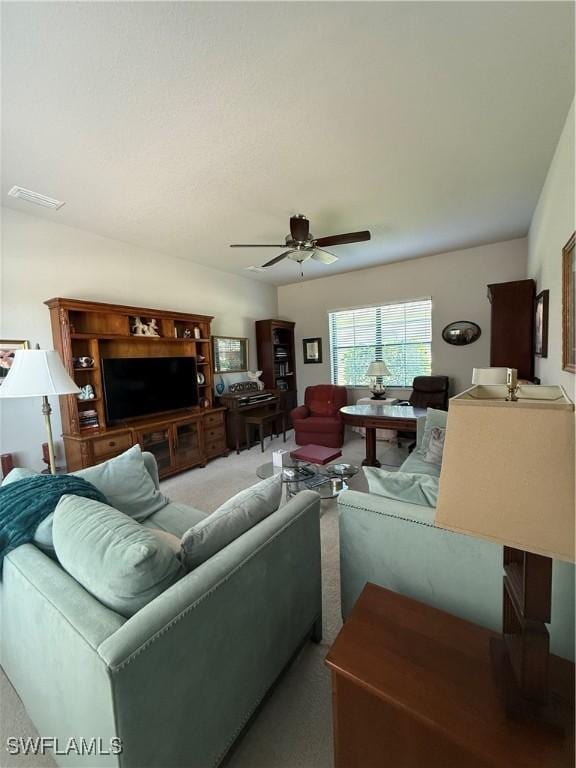 living area with visible vents, a ceiling fan, and carpet floors