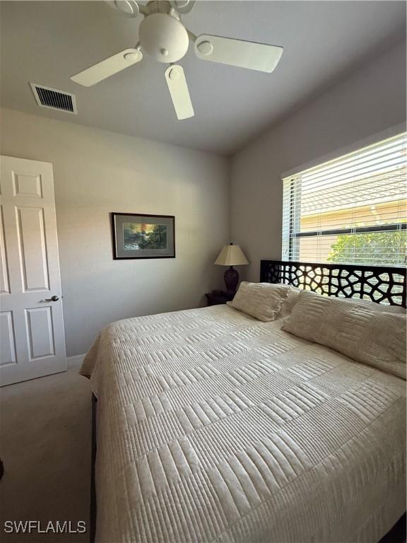 bedroom with a ceiling fan, carpet flooring, and visible vents