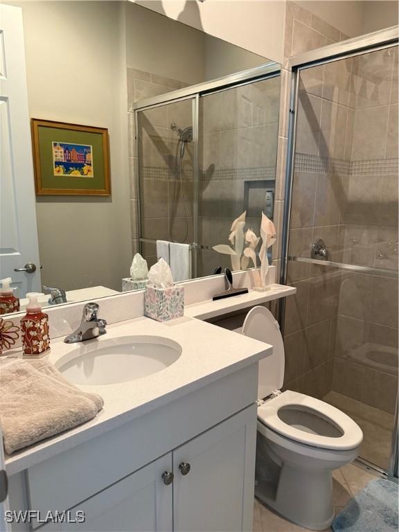 full bathroom with vanity, tile patterned floors, toilet, and a shower stall