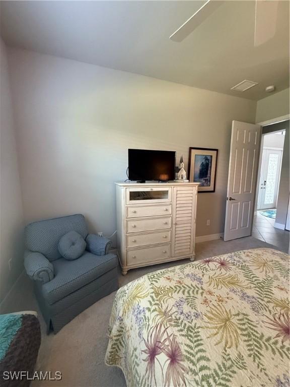 bedroom with light colored carpet and baseboards