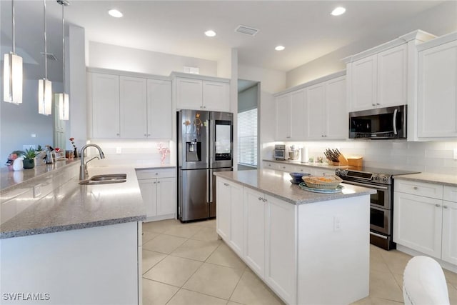 11692 Stonecreek Cir, Fort Myers, FL 33913 - kitchen featuring stainless steel appliances, a sink, a peninsula, light stone counters, and recessed lighting