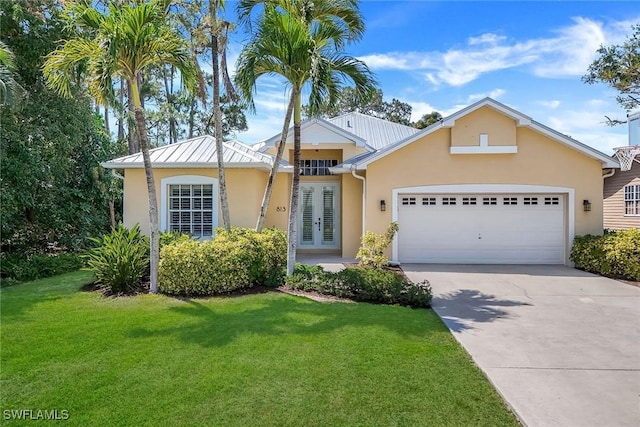 view of front of property with a garage, a front lawn, french doors, and stucco siding