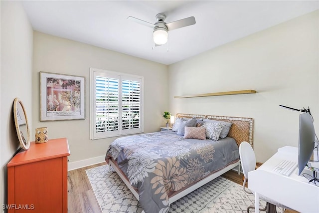 bedroom with light wood-style floors, a ceiling fan, and baseboards