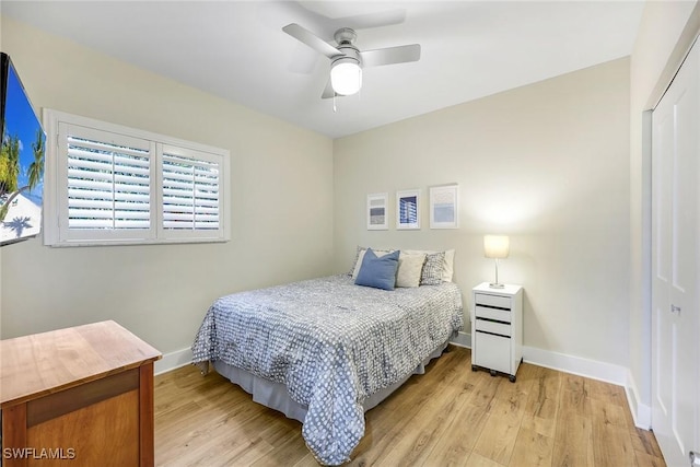 bedroom featuring light wood-type flooring, a closet, a ceiling fan, and baseboards