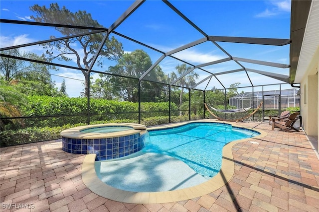 view of pool with a patio, glass enclosure, cooling unit, and a pool with connected hot tub