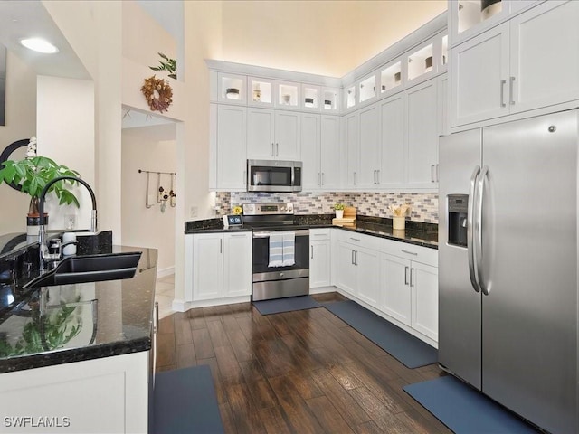 363 Pindo Palm Dr, Naples, FL 34104 - kitchen with stainless steel appliances, a sink, white cabinets, dark wood-style floors, and decorative backsplash