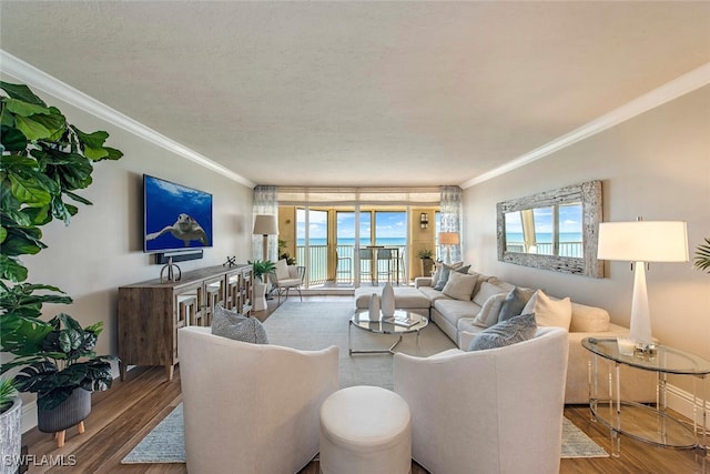 living area with crown molding, plenty of natural light, and wood finished floors
