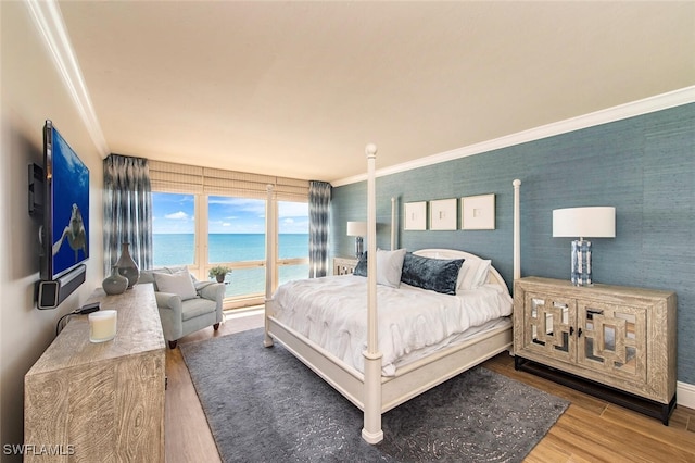bedroom with crown molding and wood finished floors