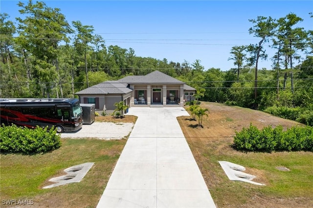 10191 Strike Ln, Bonita Springs, FL 34135 - view of front of house with driveway, a front yard, and a forest view