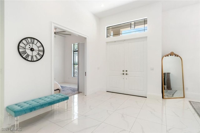 10191 Strike Ln, Bonita Springs, FL 34135 - foyer with plenty of natural light, a ceiling fan, marble finish floor, and a towering ceiling