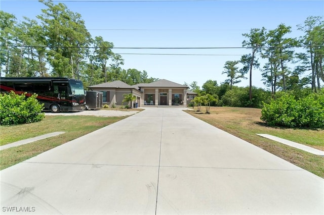 10191 Strike Ln, Bonita Springs, FL 34135 - view of front facade featuring a front yard and concrete driveway