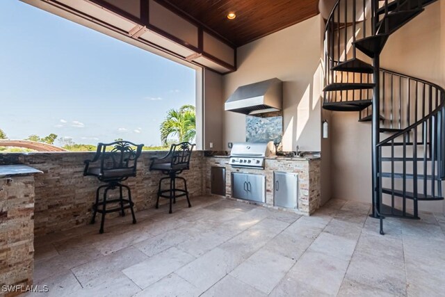 view of patio featuring stairs, outdoor wet bar, area for grilling, a sink, and a grill