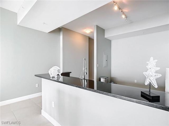 3000 Oasis Grand Blvd, Fort Myers, FL 33916 - kitchen featuring a sink, light tile patterned flooring, track lighting, baseboards, and dark countertops