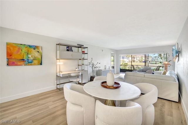 dining room featuring light wood-style floors and baseboards
