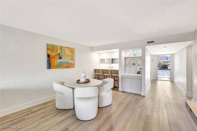 dining area with light wood-style flooring and baseboards