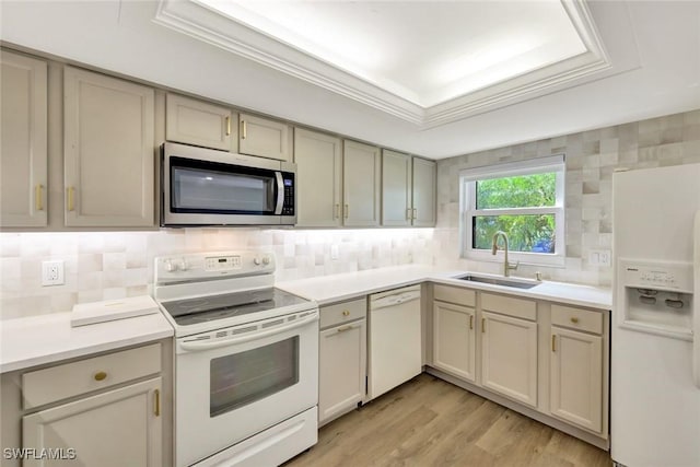 kitchen featuring white appliances, a sink, light wood-type flooring, and light countertops