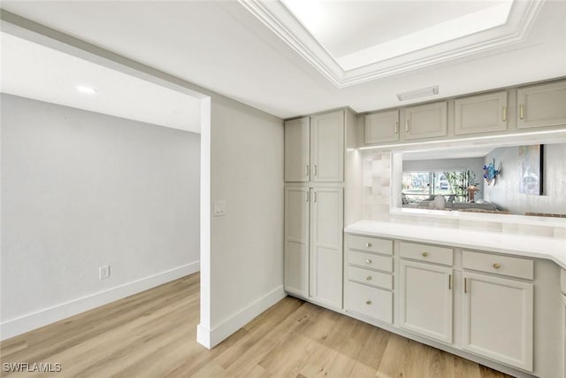kitchen featuring light wood finished floors, gray cabinetry, light countertops, and baseboards
