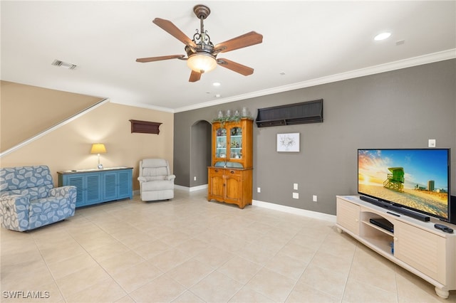 living area featuring baseboards, ornamental molding, a ceiling fan, and visible vents