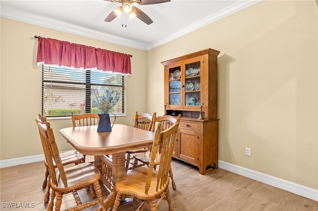 dining room with baseboards, ceiling fan, ornamental molding, and light wood-style flooring