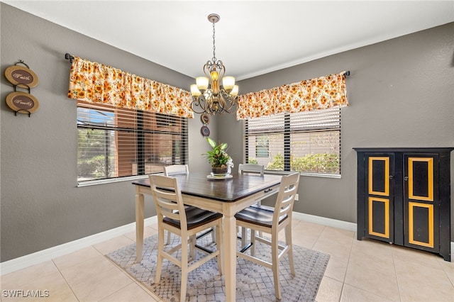 dining space featuring an inviting chandelier, baseboards, light tile patterned floors, and a healthy amount of sunlight