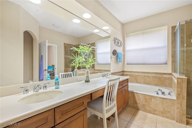 bathroom featuring a sink, tile patterned floors, a garden tub, and double vanity