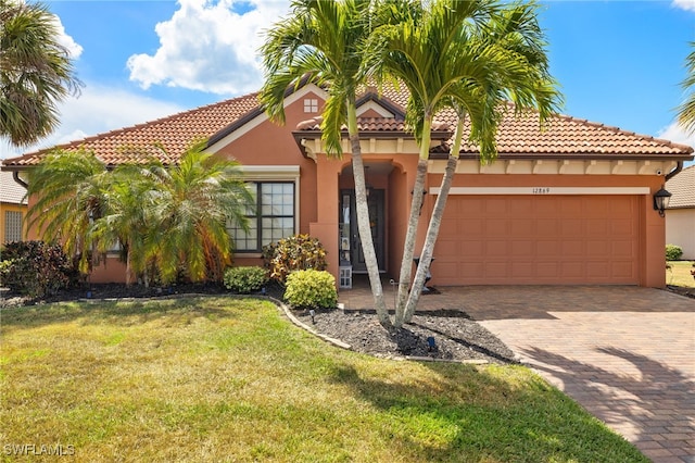 12869 Pastures Way, Fort Myers, FL 33913 - mediterranean / spanish house with stucco siding, an attached garage, a front lawn, decorative driveway, and a tiled roof