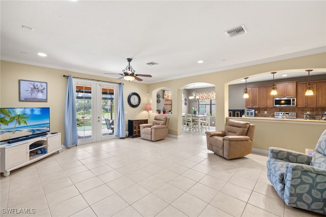 12869 Pastures Way, Fort Myers, FL 33913 - living area featuring arched walkways, light tile patterned flooring, crown molding, french doors, and recessed lighting