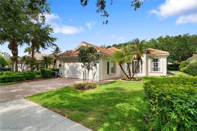 2733 Island Pond Ln, Naples, FL 34119 - mediterranean / spanish-style home featuring a tiled roof, a garage, driveway, stucco siding, and a front yard
