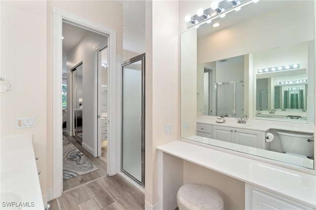 2733 Island Pond Ln, Naples, FL 34119 - ensuite bathroom with a shower stall, vanity, wood finished floors, and toilet