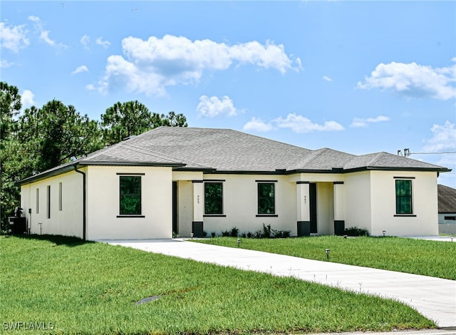 476/478 Lotus Ave S, Lehigh Acres, FL 33974 - prairie-style house with stucco siding, a front yard, and roof with shingles