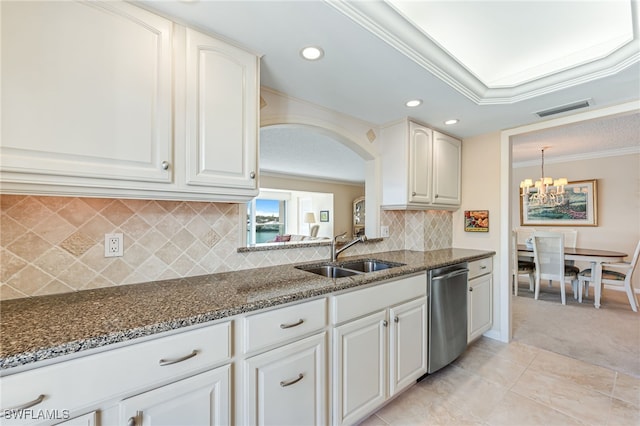 kitchen featuring a sink, stainless steel dishwasher, crown molding, dark stone countertops, and a chandelier