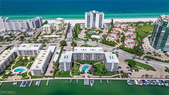 aerial overview of property's location with a large body of water, a pool, and nearby urban area