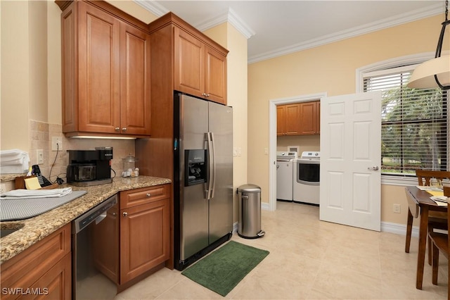 184 Vintage Cir Unit N202, Naples, FL 34119 - kitchen featuring crown molding, brown cabinets, independent washer and dryer, and stainless steel appliances