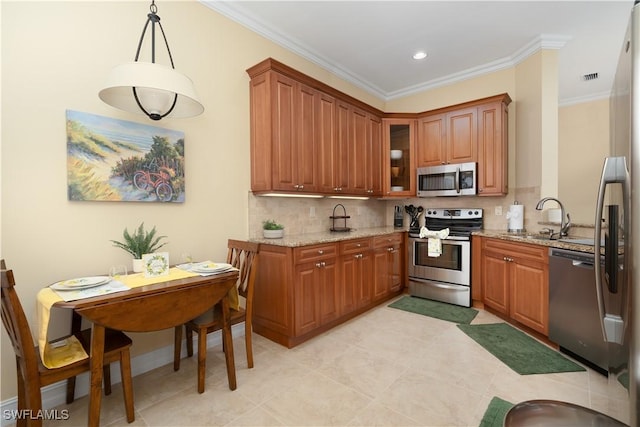 184 Vintage Cir Unit N202, Naples, FL 34119 - kitchen with tasteful backsplash, light stone countertops, stainless steel appliances, brown cabinets, and a sink