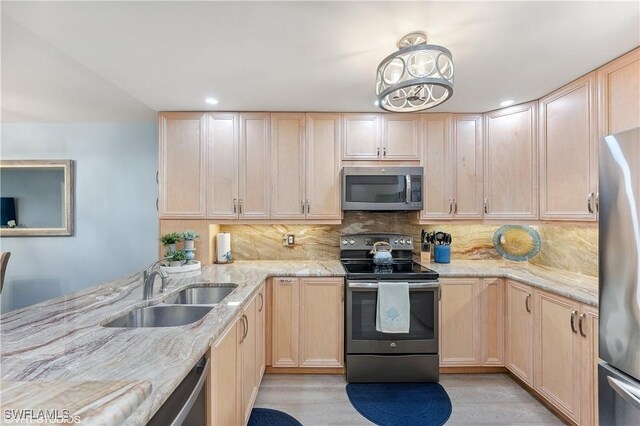 26000 Hickory Blvd Unit 604, Bonita Springs, FL 34134 - kitchen featuring light brown cabinets, light stone counters, a sink, and appliances with stainless steel finishes