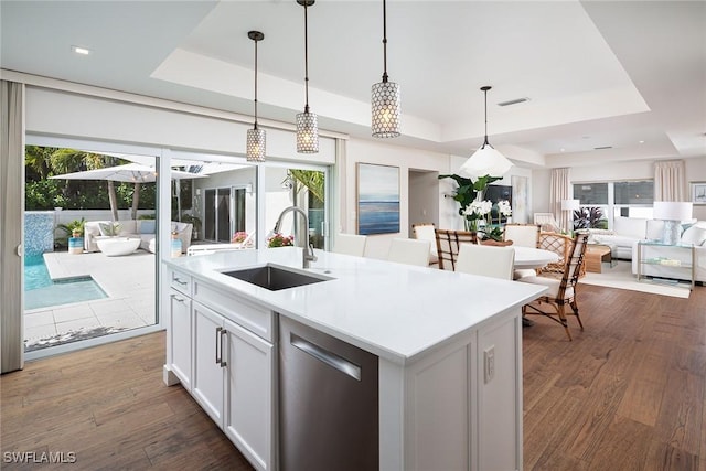 4830 W Blvd, Naples, FL 34103 - kitchen with a tray ceiling, stainless steel dishwasher, open floor plan, decorative light fixtures, and light countertops