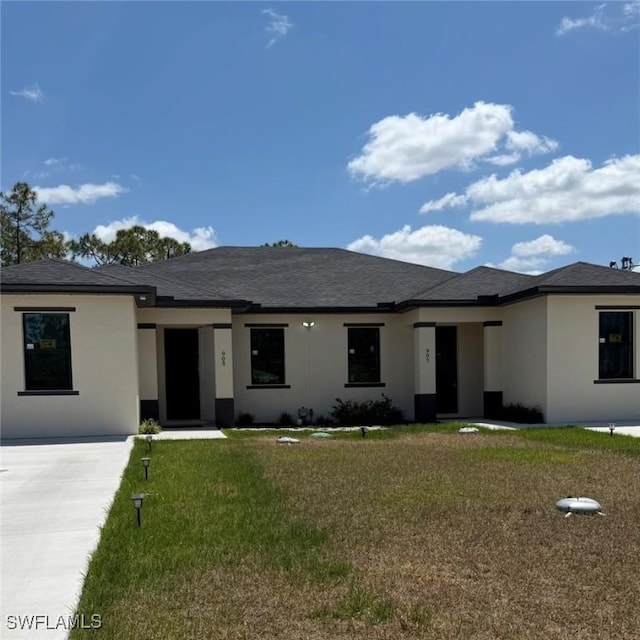 view of front of property with stucco siding and a front yard