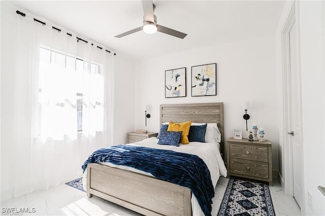 bedroom with marble finish floor and ceiling fan