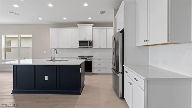 17825 Summerland Key Ct, Fort Myers, FL 33908 - kitchen featuring appliances with stainless steel finishes, a sink, white cabinets, a center island with sink, and recessed lighting