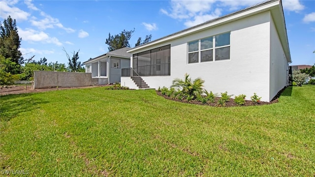 17825 Summerland Key Ct, Fort Myers, FL 33908 - back of property with stucco siding, a sunroom, and a yard