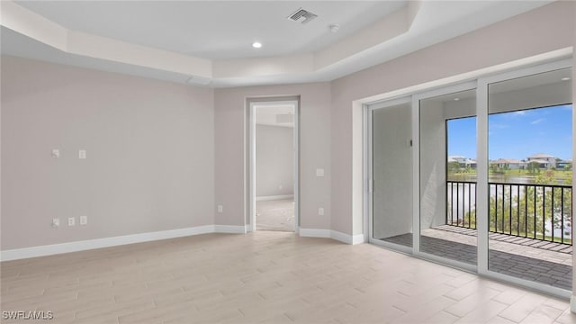 17825 Summerland Key Ct, Fort Myers, FL 33908 - spare room featuring a tray ceiling, light wood-style flooring, baseboards, recessed lighting, and a water view