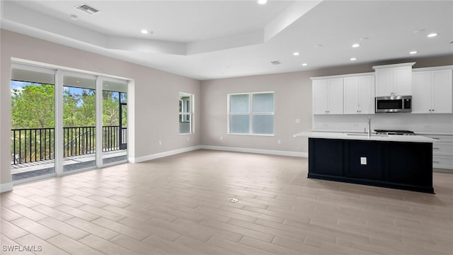 17825 Summerland Key Ct, Fort Myers, FL 33908 - kitchen with stainless steel microwave, light countertops, baseboards, recessed lighting, and white cabinets